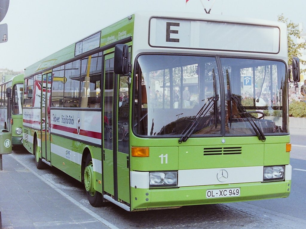 Wagen 11, OL-XC 949, EZ: 02.09.1987. Die neue Generation von Linienbussen erreichte Oldenburg pnktlich zum Kramermarkt im September 1987. Wagen 11, ein Daimler Benz O 405, war der erste Bus des neuen Standardlininenbus Typ II fr die VWG. Erst wenige Monate vorher waren die Setra mit den Wagen 11 bis 18 ausgeschieden. Als die Fahrzeuge 1976 angeschafft wurden, waren es nicht nur andere als die gewohnten Busse des Typ SL I, Pekol begann damals auch die Fahrzeuge wieder neu zu nummerieren und man fhrte einen neuen Farbton ein. Jetzt, 11 Jahre spter, begann die Benummerung wieder bei der 11, es gab wieder einen neuen Bustyp und wieder eine neue Farbe. Und eine weitere alte Tradition wurde wieder eingefhrt : Die Busse wurden zum Kramermarkt wieder beflaggt. Das Foto zeigt Wagen 11 am 26.09.87, dem offiziellen Kramermarktbeginn, am Stadtmuseum West.
