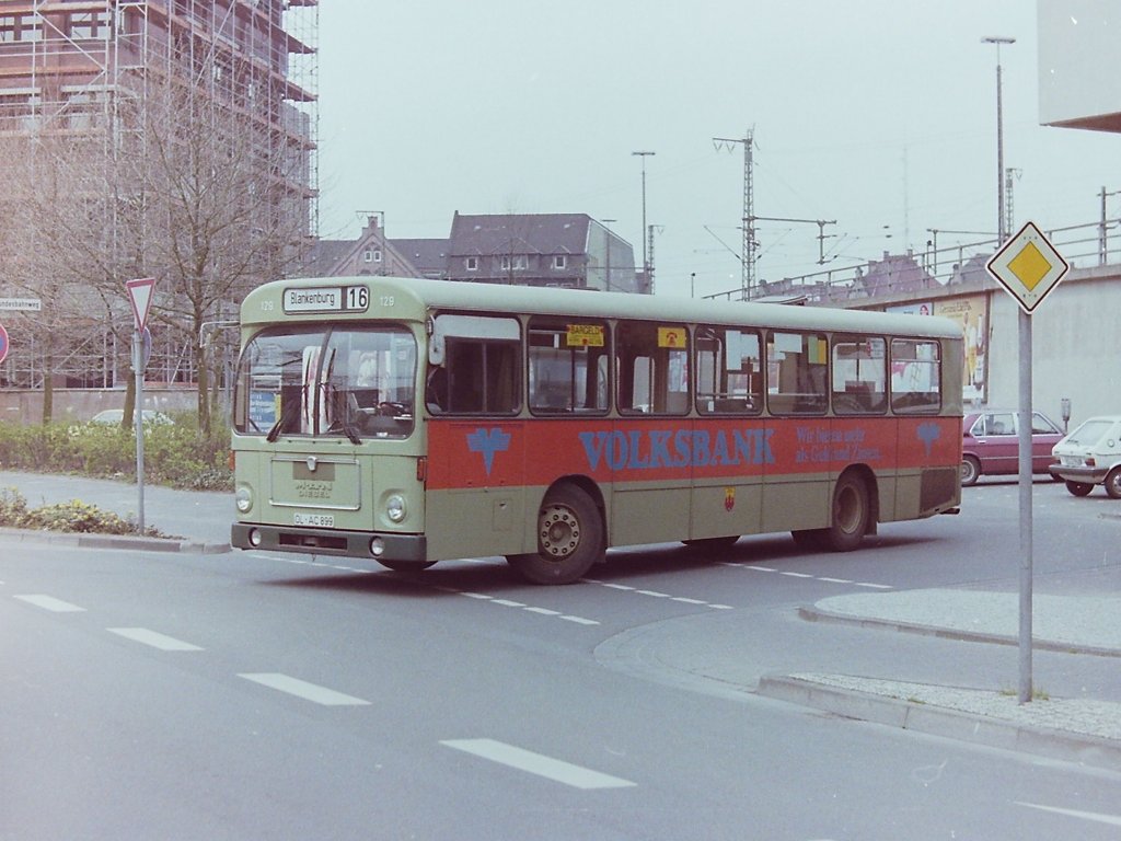 Wagen 129, OL-AC 899, EZ: 1973. Der Bus verlt gerade den Reserveparkplatz im Bundesbahnweg um wieder auf die Linie 16 zu gehen. Die Aufnahme entstand am 26.04.83. Im Gegensatz zu Wagen 132 war bei diesem Bus die Werbung in Bandenhhe um das Heck herumgezogen.