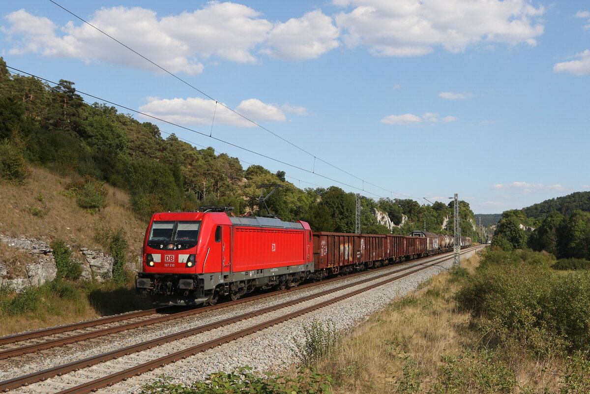 187 210 mit einem gemischten G�terzug am 9. August 2022 bei Hagenacker im Altm�hltal.